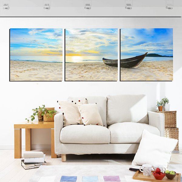3-teilige Leinwand-Kunstdrucke „Einsames Boot am Strand im Sonnenuntergang“.